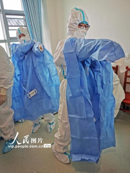 2月22日，武汉同济医院中法新城院区，准备进入隔离病区的北京医院医疗队医护小组正在穿戴隔离装备。医护人员分组轮班进入隔离病区工作，每次进入，护士们都要认真准备将近半个小时，至少穿戴8件装备，穿越5道隔离门进入“红区”，再在里面工作至少4个小时。北京医院医疗队专门配备了感控帮助医护人员穿戴，检查疏漏，力争做到万无一失。（陈黎明 人民图片）