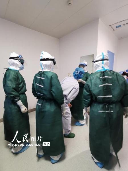 2月22日，武汉华中科技大学同济医学院附属同济医院中法新城院区，北京医院国家医疗队负责的病区，“感控”护士正在仔细检查即将进入隔离病房医护人员的隔离装备。（陈黎明 人民图片）